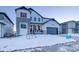 Two-story home with gray siding, red accents, and a snowy front yard at 8512 Orchard City Dr, Littleton, CO 80125
