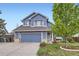 Charming two-story home featuring a well-maintained lawn, blue siding, and an attached two-car garage at 1663 E 96Th Pl, Thornton, CO 80229