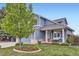 Inviting blue home showcasing a cozy porch swing, lush lawn, and mature landscaping at 1663 E 96Th Pl, Thornton, CO 80229