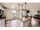 Bright kitchen with a center island, tile floors, and views into the living area with a fireplace at 1663 E 96Th Pl, Thornton, CO 80229