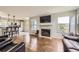 Open-concept living space with a fireplace, hardwood floors, and a seamless transition to the kitchen at 1663 E 96Th Pl, Thornton, CO 80229