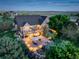 Back of property with a lit patio featuring outdoor dining and entertainment space and lush landscaping at 34827 E 7Th Ave, Watkins, CO 80137