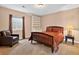 Bedroom with a wooden bed frame, carpeted floors, and a well-lit window creating a warm, inviting space at 34827 E 7Th Ave, Watkins, CO 80137