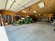 Spacious garage with concrete floor, wood paneled ceiling and walls, large storage racks and room for a tractor at 34827 E 7Th Ave, Watkins, CO 80137