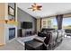 The living room has a tiled fireplace and is bathed in natural light from the expansive windows and sliding glass door at 34827 E 7Th Ave, Watkins, CO 80137