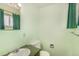 Compact bathroom with a pedestal sink, toilet, and green color scheme at 4395 E Arapahoe Pl, Centennial, CO 80122