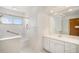 Bright bathroom features a vanity with white cabinets and a shower with grab bars at 4395 E Arapahoe Pl, Centennial, CO 80122
