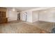 Spacious open-concept living room featuring a built-in bookshelf and neutral carpeting at 4395 E Arapahoe Pl, Centennial, CO 80122