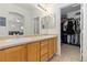 Bright bathroom featuring a double sink vanity and an adjacent walk-in closet for ample storage at 32 Whitehaven Cir, Highlands Ranch, CO 80129