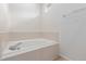 Soaking tub in bathroom featuring minimal tile surround and a small window for natural light at 32 Whitehaven Cir, Highlands Ranch, CO 80129