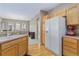 Kitchen area with wood floors, cabinets, white refrigerator, and eat-in dining area at 32 Whitehaven Cir, Highlands Ranch, CO 80129