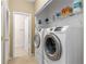 Convenient laundry room featuring modern, front-load washer and dryer, as well as shelving for storage at 32 Whitehaven Cir, Highlands Ranch, CO 80129