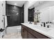 This bathroom features a double sink vanity, black backsplash, and modern fixtures at 7611 Copper Sky Ct, Castle Pines, CO 80108