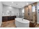 Elegant bathroom featuring a soaking tub, glass-enclosed shower, and sleek vanity with modern lighting at 7611 Copper Sky Ct, Castle Pines, CO 80108