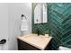 Modern powder room with stylish tile accent wall, unique mirror, and quartz vanity at 7611 Copper Sky Ct, Castle Pines, CO 80108