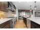 Gourmet kitchen with stainless appliances, custom cabinetry, stone backsplash, and island with sink at 7611 Copper Sky Ct, Castle Pines, CO 80108
