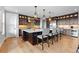 Modern kitchen with dark wood cabinets, stainless steel appliances, and an expansive center island at 7611 Copper Sky Ct, Castle Pines, CO 80108