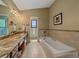 Bathroom featuring a soaking tub, tiled shower, dual sinks, and granite countertops at 31412 N Bermuda Dunes Dr, Evergreen, CO 80439