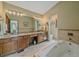 This primary bathroom features double sinks, a large mirror and a luxurious tub at 31412 N Bermuda Dunes Dr, Evergreen, CO 80439