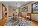 Bright dining room with hardwood floors, a stylish rug, and a glass-top dining table at 31412 N Bermuda Dunes Dr, Evergreen, CO 80439