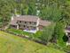 Aerial view of a cozy home with a backyard deck enclosed by a wooden fence with lush green grass at 31412 N Bermuda Dunes Dr, Evergreen, CO 80439