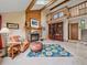 Cozy living room featuring a stone fireplace, wooden beams, and a striking blue floral rug at 31412 N Bermuda Dunes Dr, Evergreen, CO 80439