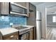 Cozy kitchen equipped with stainless steel appliances, blue backsplash, and ample counter space at 361 N Raleigh St, Denver, CO 80219