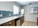 Well-lit kitchen with stainless steel appliances, stylish blue tile backsplash, and in-unit washer/dryer at 361 N Raleigh St, Denver, CO 80219
