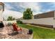 Serene backyard featuring a stone patio, green lawn, white fence, and lush trees, perfect for relaxing and outdoor activities at 5400 Perth St, Denver, CO 80249