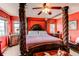 Elegant primary bedroom with a four-poster bed, dark wood furniture, and ample natural light at 5400 Perth St, Denver, CO 80249