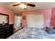 Bedroom with painted pink walls, ceiling fan, and closet at 5400 Perth St, Denver, CO 80249