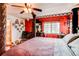 Charming bedroom with red accent wall, decorative details, and a glimpse into the en-suite bathroom at 5400 Perth St, Denver, CO 80249