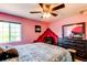 Bedroom with window, ceiling fan, dark wood dresser, and painted accent wall at 5400 Perth St, Denver, CO 80249