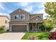 Beautiful two-story home featuring neutral siding, a covered entry, an attached garage, and a neatly kept front lawn at 5400 Perth St, Denver, CO 80249