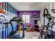 Well-equipped home gym featuring sports memorabilia, treadmill, elliptical machine, and bright wall decor at 5400 Perth St, Denver, CO 80249