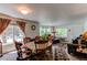 Open-concept living and dining area with wood furniture, large windows, and comfortable seating, perfect for entertaining at 5400 Perth St, Denver, CO 80249