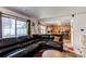 Comfortable living room space with kitchen view, plush seating, and large windows at 5400 Perth St, Denver, CO 80249