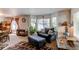 Cozy living room featuring comfortable seating, a patterned rug, and large windows that provide ample natural light at 5400 Perth St, Denver, CO 80249