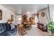 Spacious living area with wood dining set, comfortable blue sofa, and natural light from the large windows at 5400 Perth St, Denver, CO 80249