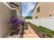 Charming side yard with stone pathway, colorful flowers, lush greenery, and a white fence, adding curb appeal at 5400 Perth St, Denver, CO 80249
