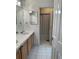 Double vanity bathroom with wood cabinets and shower at 6297 W Prentice Ave, Littleton, CO 80123