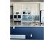 Kitchen features white cabinets, blue backsplash, and a large island at 6297 W Prentice Ave, Littleton, CO 80123