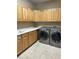 Laundry room with wood cabinets and LG washer/dryer at 6297 W Prentice Ave, Littleton, CO 80123