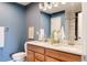 Stylish bathroom with a double sink vanity, modern lighting, and contrasting wall colors at 3415 Florence Way, Denver, CO 80238