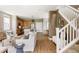 Bright living room with hardwood floors, open to the kitchen and adjacent to staircase at 3415 Florence Way, Denver, CO 80238