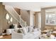 Bright living room featuring a white sofa, modern decor, and a staircase with white banisters at 3415 Florence Way, Denver, CO 80238
