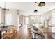Kitchen and dining area open to Gathering room with contemporary lighting and natural light at 3415 Florence Way, Denver, CO 80238