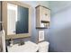 Cozy powder room featuring a decorative mirror, light fixtures, and storage cabinet at 3415 Florence Way, Denver, CO 80238