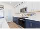 Modern kitchen features white countertops, navy cabinets, and stainless steel appliances at 11033 Olathe St, Commerce City, CO 80022