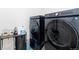 Modern laundry room featuring front load washer and dryer, storage cart and organized laundry supplies at 11033 Olathe St, Commerce City, CO 80022